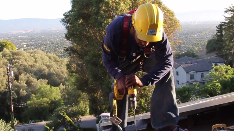 Video still of worker installing solar panel from Chasing the Sun by 7th Empire Films